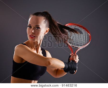 Female tennis player with racket ready to hit a tennis .