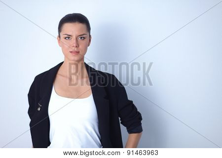 A young woman standing, isolated on graybackground