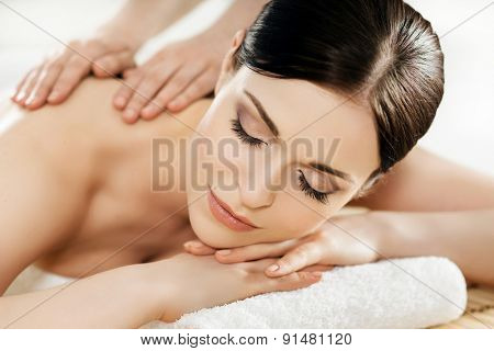 Young and healthy woman in spa salon. Traditional Swedish massage therapy and beauty treatments. 