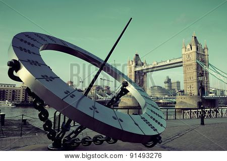 Tower Bridge and sundial over Thames River in London.