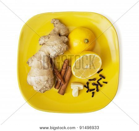 Ginger, Cinnamon, Lemon, Garlic And Cloves On The Yellow Plate