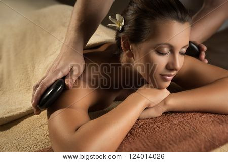 Massage with hot basalt stones. Beautiful deep charming light.