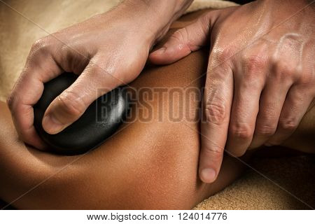 Massage with hot basalt stones. Close-up. Spa treatment.
** Note: Shallow depth of field