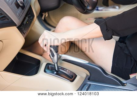Hand driver shifting gear stick before driving car.