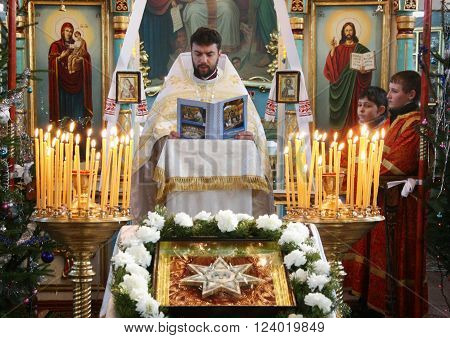 VOYUTYN UKRAINE - JANUARY 08: Orthodox priest and little sexton during Christmas service in Voyutyn on January 08 2009.