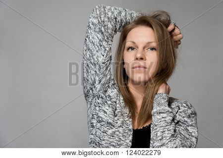 Beautiful blond winter fashion woman in a gray sweater