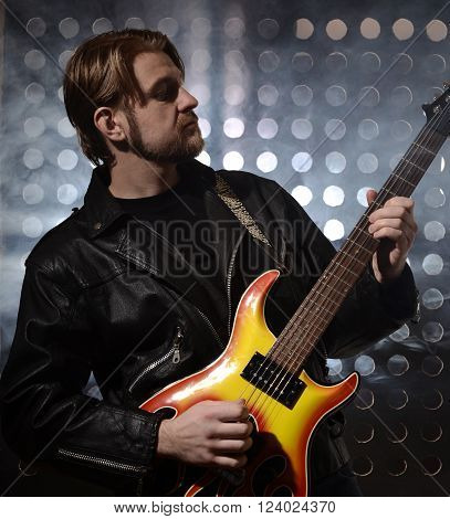rock guitarist playing electric guitar in fog