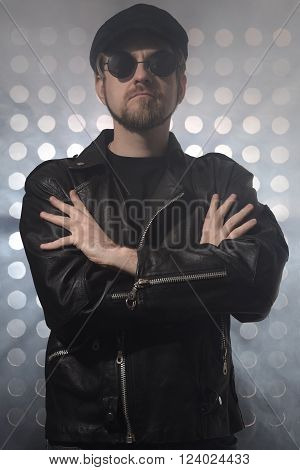 Portrait of young handsome brutal bearded biker in leather jacket and sunglasses.