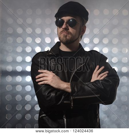 Portrait of young handsome brutal bearded biker in leather jacket and sunglasses.