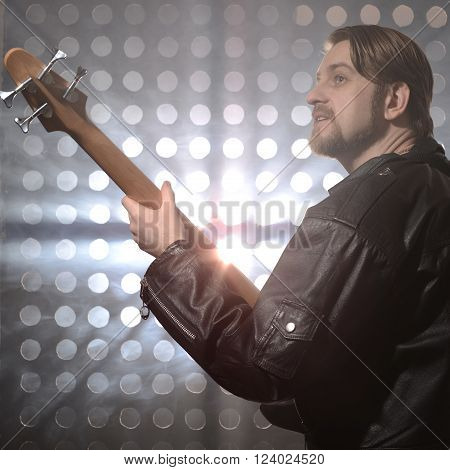 Bassist playing bass guitar in smoke. backlight