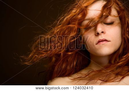Sexy Redhead Woman with Blurred Curly Hair