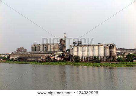Factory and silo near the river with Water Hyacinth