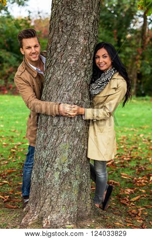 enamoured couple behind a tree