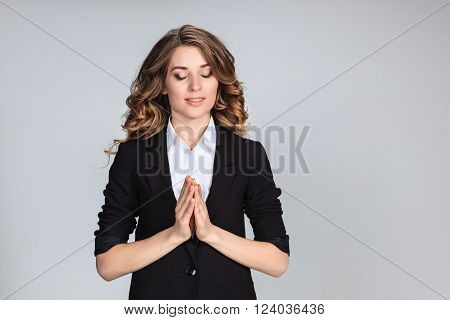 Woman wearing a blue shirt is looking imploring. Over gray background