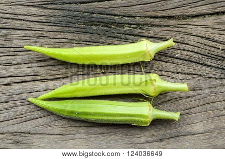 green Okra on wooden floor , Abelmoschus esculentus