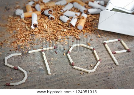 Broken cigarettes and tobacco and matches. Quit smoking now