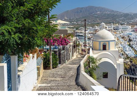 THIRA, SANTORINI, GREECE - AUGUST 24, 2015: Stony road to Thira town among churches and traditional houses on Santorini island, Greece