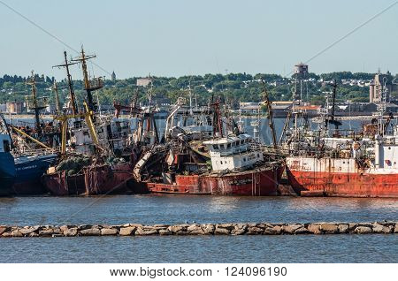Montevideo, Uruguay - December 15, 2012: The abandoned old rusty ship in the Port of Montevideo, Uruguay at December 15, 2012. Montevideo in the background.