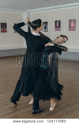 Professional dancers dancing in ballroom. Young couple