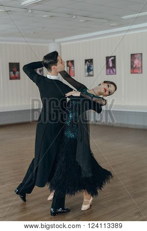 Professional dancers dancing in ballroom. Young couple