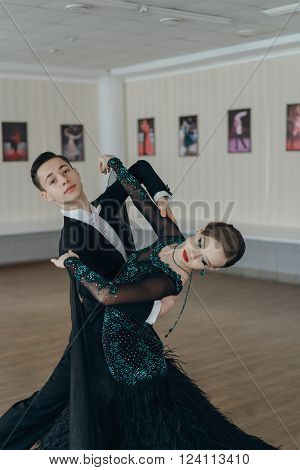 Professional dancers dancing in ballroom. Young couple
