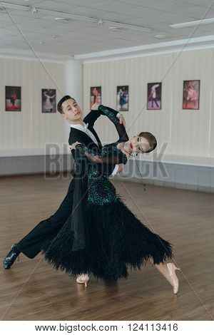Professional dancers dancing in ballroom. Young couple