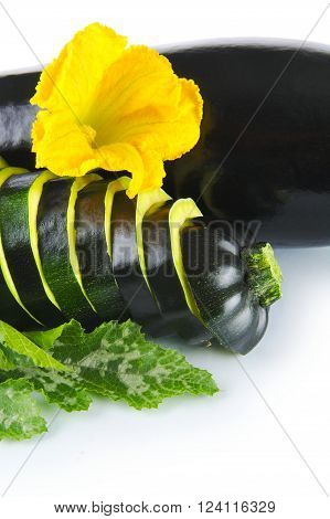 Courgette cut into slices and leaves on white