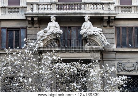 Milan (Lombardy Italy) facade of a historic palace in Eleonora Duse square with two statues