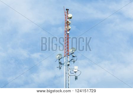 White and red color antenna repeater tower on blue sky telecommunication concept