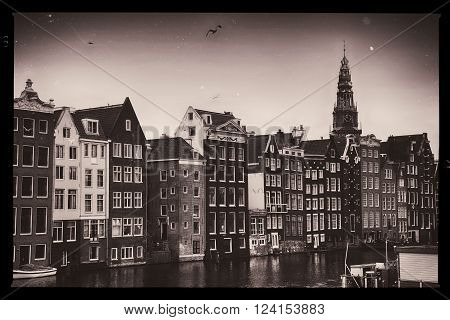 Beautiful views of the ancient buildings at the waterside and view of Oude Kerk (Old Church) from Damrak canal in Amsterdam the Netherlands