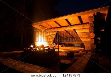 Lean-to campsite and fire in forest at night