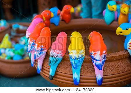 colorful parrot baked clay dolls in the garden