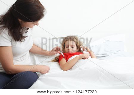 mother measuring fever of her sick child
