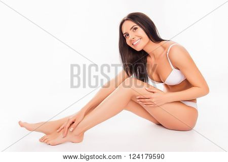 Cute Pretty Young Woman Sitting In White Underwear And  Touching Her Legs