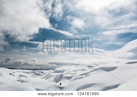Winter panorama with snow covered slopes and dramatic sky. Komna, Slovenia.