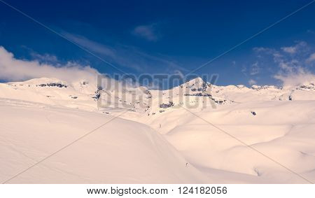 Winter panorama with snow covered slopes and dramatic sky. Komna, Slovenia.