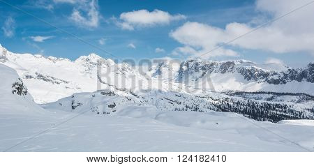 Winter panorama with snow covered slopes and dramatic sky. Komna, Slovenia.