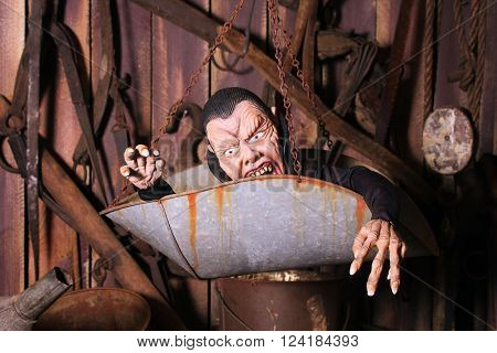 Scary vampire puppet hiding in an old weigh scale inside a
rustic barn