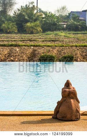 a little stone elephant on the pond