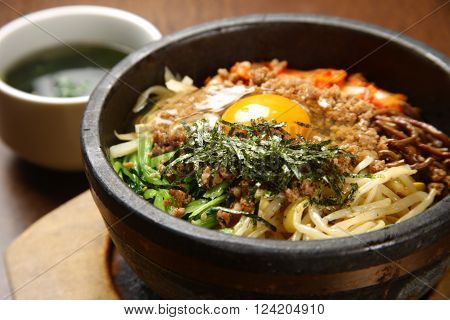 close up shot of bibimbap in a stone bowl