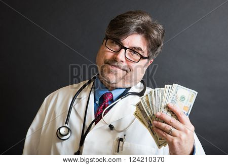 Doctor holding up a large amount of cash