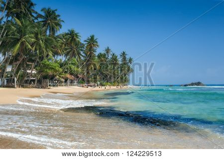 Unidentified people on the beach at Hikkaduwa. Hikkaduwa's beach and night life make it a popular tourist destination. Sri Lanka