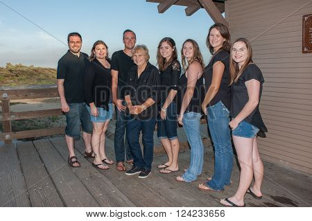 Smiling teenage cousins surrounding their loving grandmother.