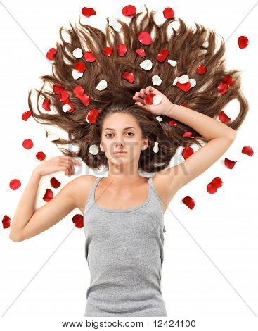 Junge schöne Brünette Frau mit langen Haaren zerstreuten und Rose Petals