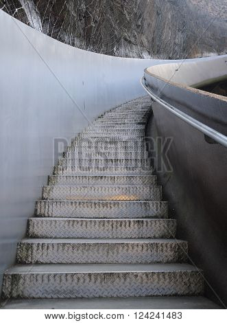 Metal diamond plate stairs leading up within the quarry at Chenshan botanical garden in Shanghai China.