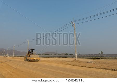 Petchaburi, Thailand - February 20, 2016: One worker drives soil compactor in the under construction solar farm on February 20, 2016 in Petchaburi, Thailand