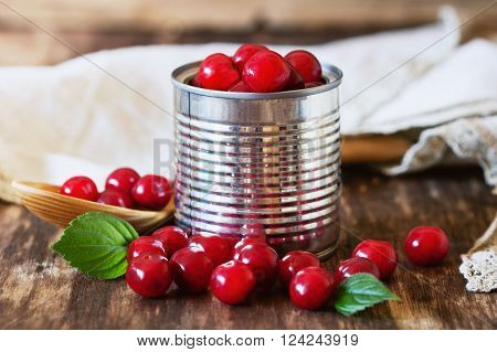 Fresh ripe cherries in a metal tin can on rustic wooden table. Preservation of products concept . Bio healthy food. Organic fruits. Selective focus