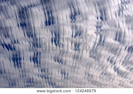 Beautiful delicate decorative abstract background in blue and white tones with an ornament of vertical wavy lines and stripes