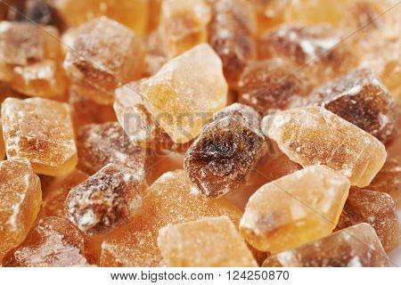 Surface coated with multiple large brown rock sugar crystals as a background composition