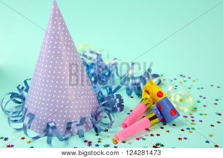 Dotted Birthday hat with serpentine streamer and noise makers on light blue background